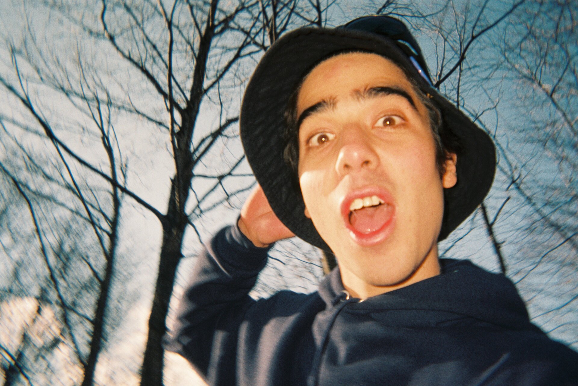 Person in a bucket hat under bare trees